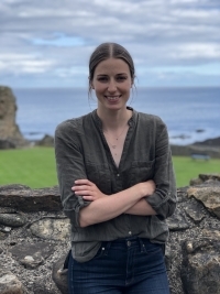 Woman smiling in front of the sea.