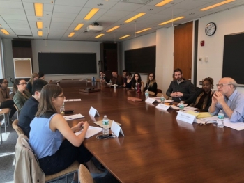 Symposium members sit at table 