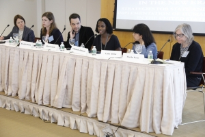 symposium members sit at a table 