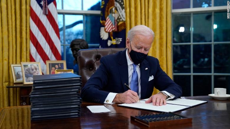 Joe Biden signing executive orders.