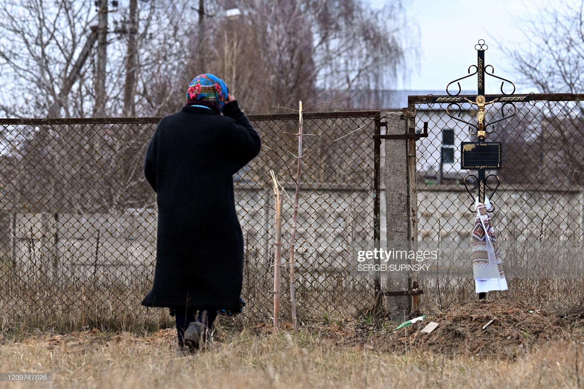A woman crosses herself at the place of a mass grave in the town of Borodianka, northwest of Kyiv, on April 4, 2022.