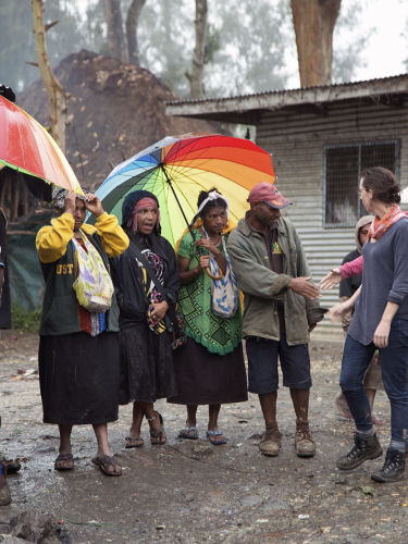 People clustered beneath umbrellas.